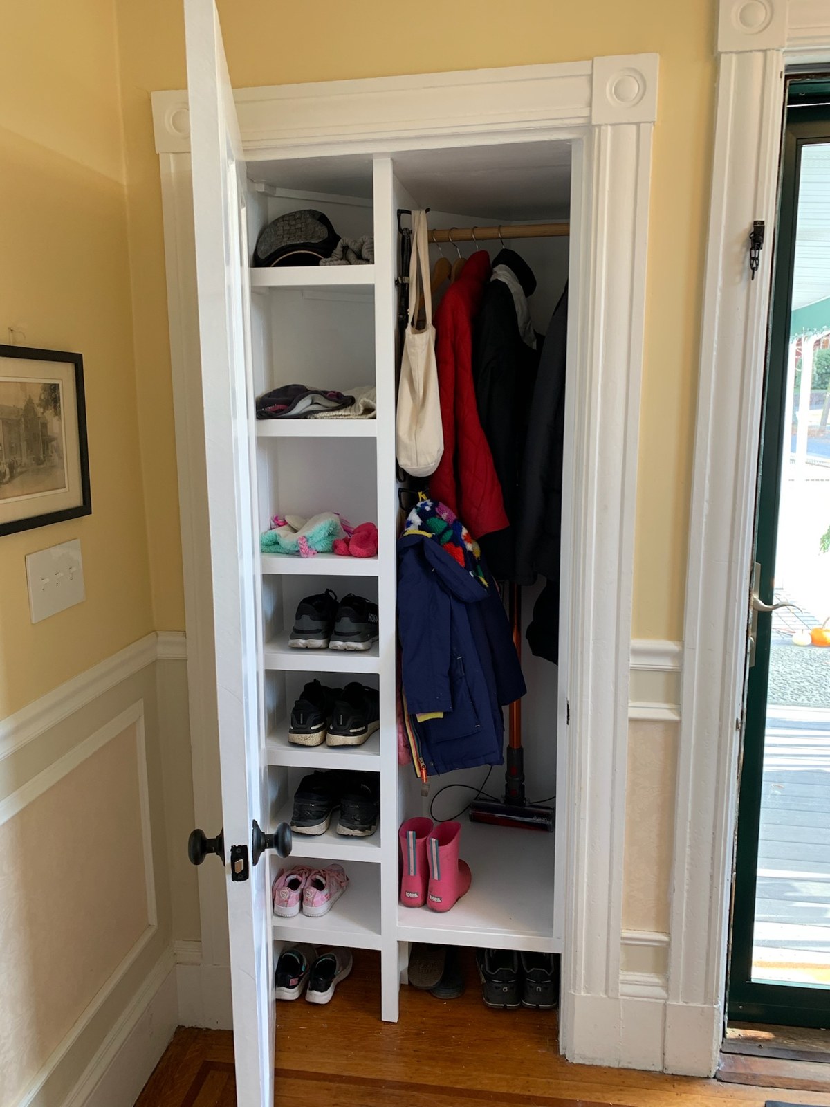 Completed entryway closet with shelves and coat rod