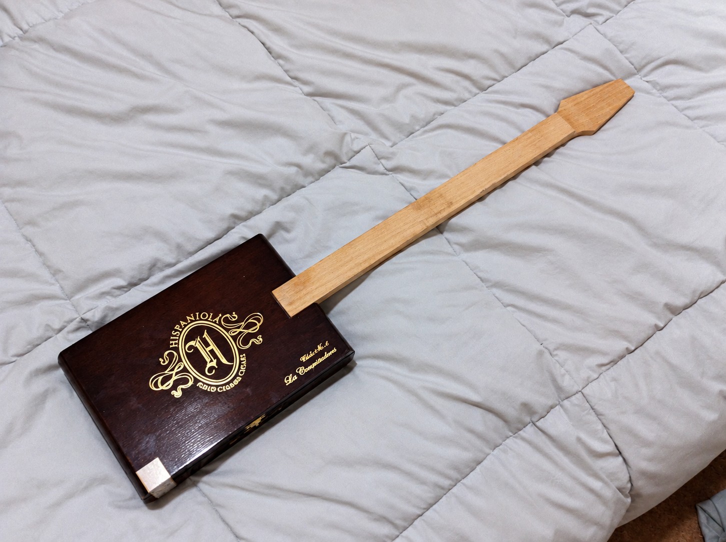 Shaped wooden neck fitted to the cigar box before hardware installation