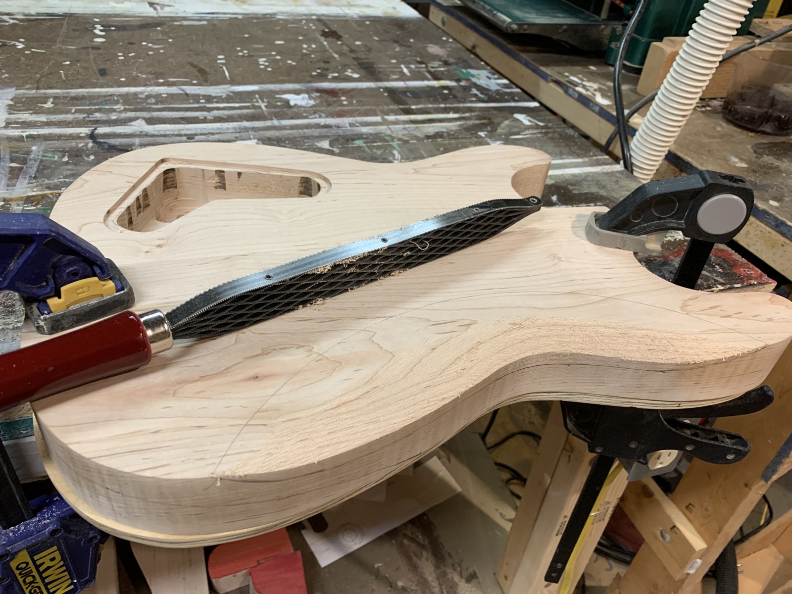 Chisel work on the rear control cavity of the bare guitar body