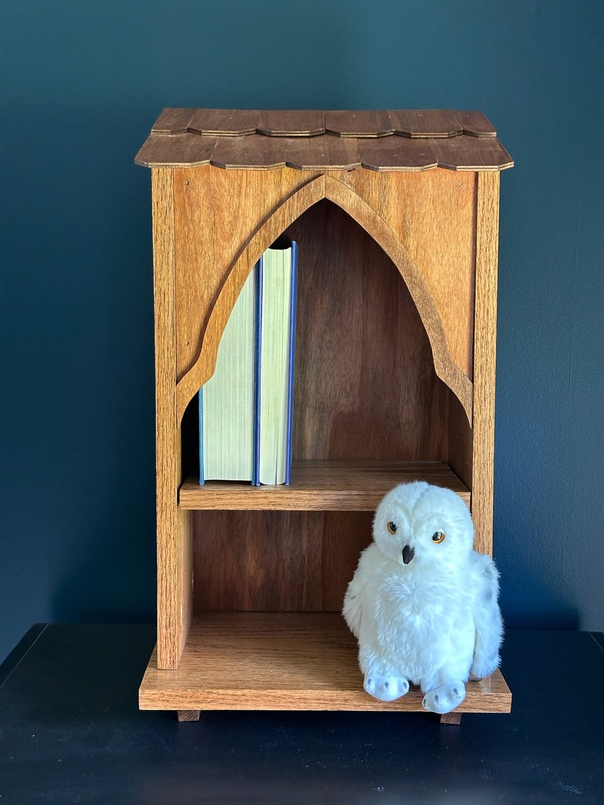 Front view of the completed Owlery with books on the upper shelf and a stuffed white owl on the lower shelf