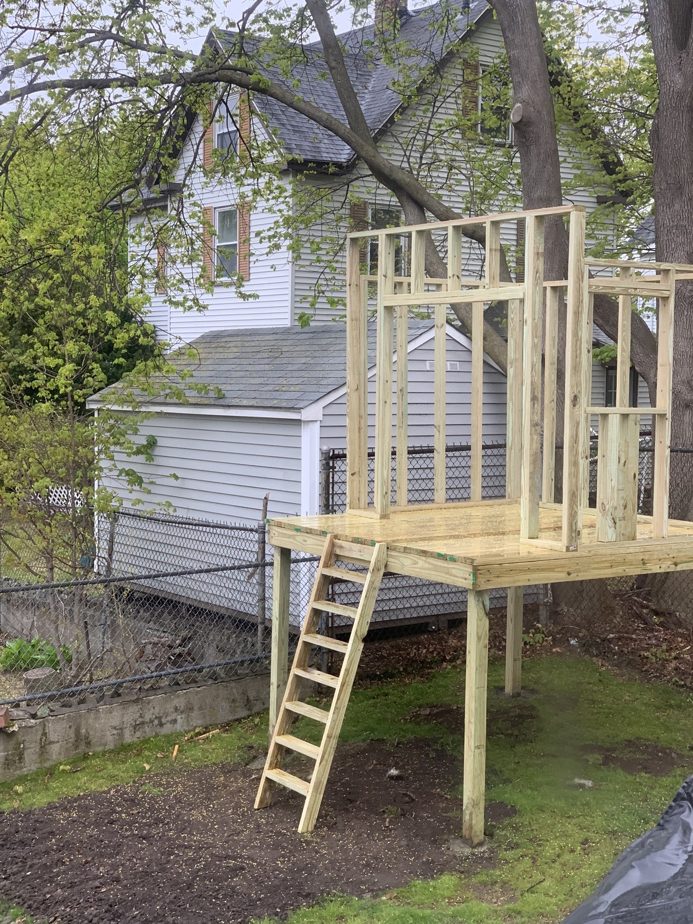 Wooden ladder installed against the framed play structure